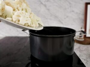 adding cauliflower florets to pot