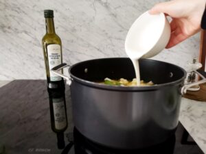 adding cooking cream to soup