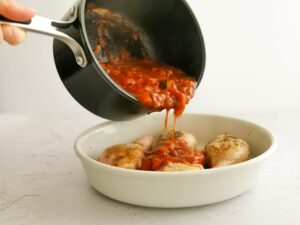 adding tomato sauce to chicken