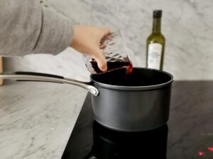 adding wine to tomato sauce