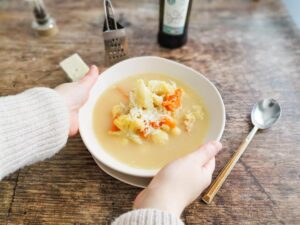 enjoying a bowl of cauliflower soup at home