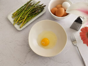 cracking eggs for frittata in a bowl