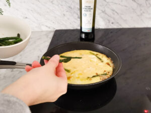 topping frittata with asparagus