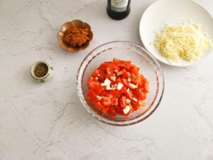 adding garlic to cherry tomatoes