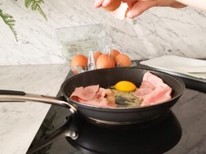cracking eggs in a pan