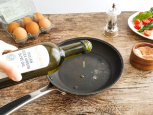 drizzling oil in a pan to fry eggs