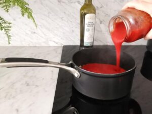 pouring passata to make tomato sauce