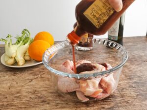 adding BBQ sauce to chicken wings