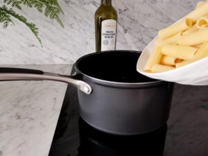 adding rigatoni pasta to pot