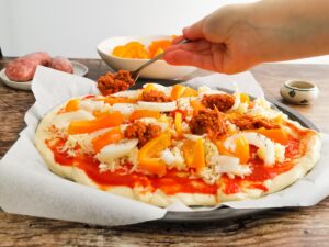 adding spicy Cannonata sauce on pizza with sausage
