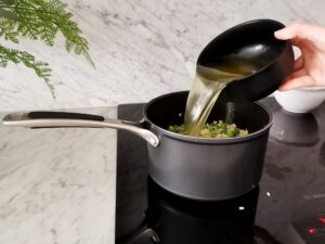 adding vegetable stock to pea risotto