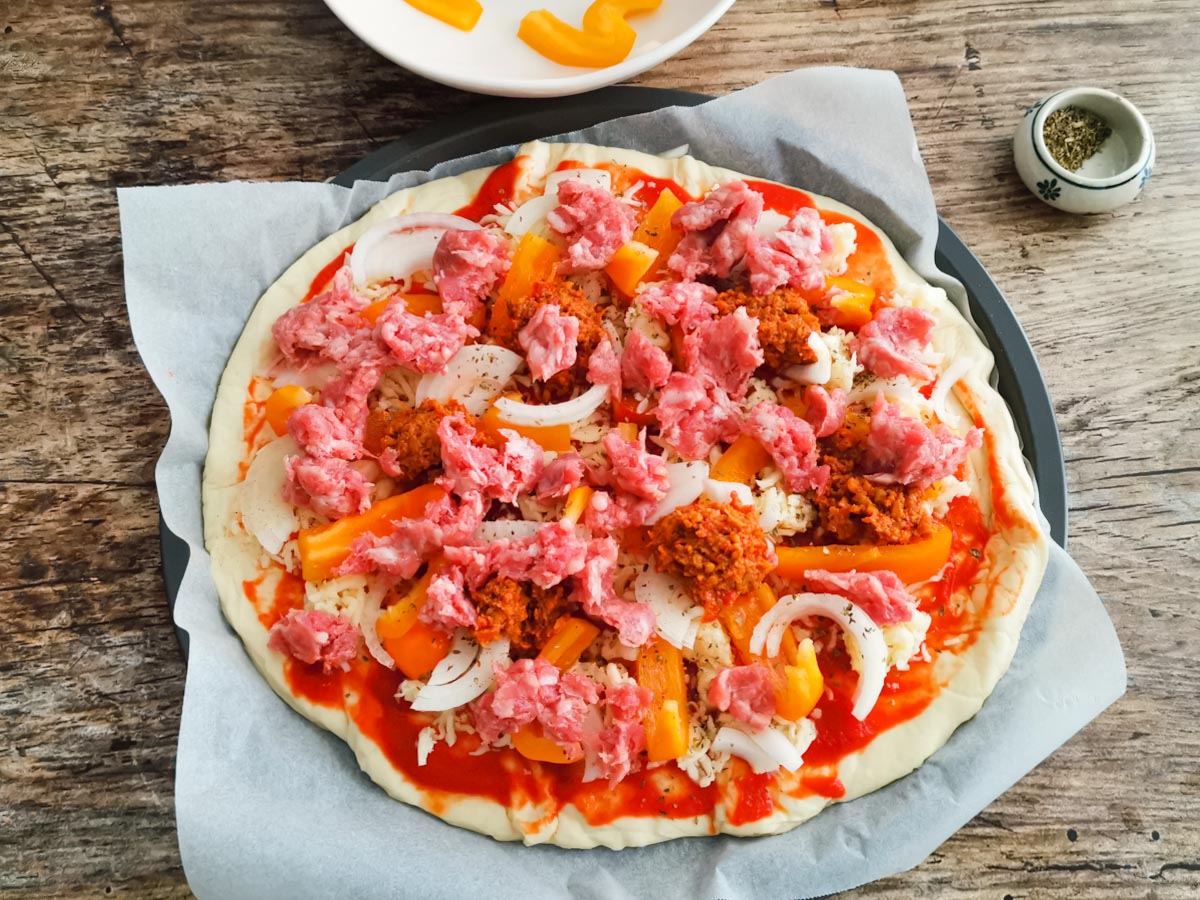 pizza with sausage before going in the oven