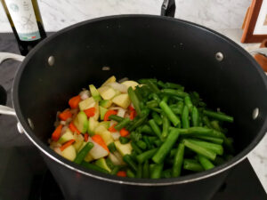 stir frying vegetables for minestrone with pesto