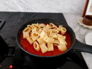 mixing calamarata pasta and tuna sauce